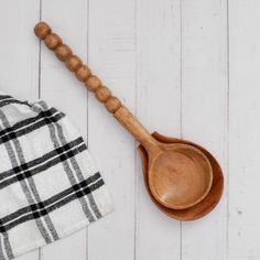 a wooden spoon sitting on top of a white table next to a towel and napkin