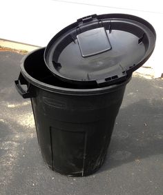 a black trash can sitting on the ground