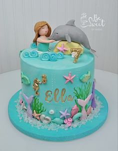 a birthday cake with a dolphin and mermaid on top