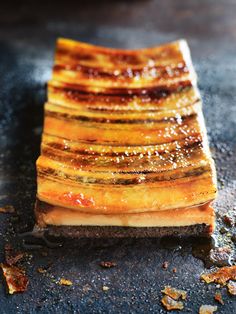 slices of food sitting on top of a black counter next to seasoning flakes