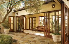 the entrance to a home with large windows and doors