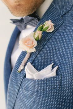 a man in a blue suit with a boutonniere on his lapel