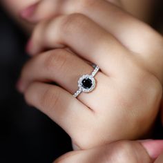 a woman's hand with a black and white diamond ring