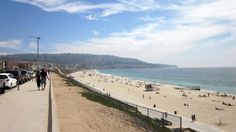 people are walking along the beach on a sunny day