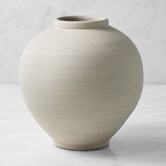 a white vase sitting on top of a table