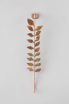 a gold leaf brooch pin on a white background