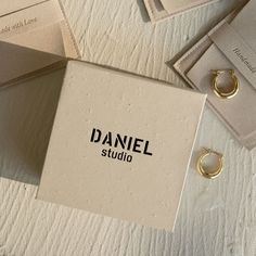 a box with some rings on top of it next to other boxes and tags that say, daniel studio