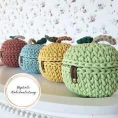 three crocheted apples sitting on top of a white shelf