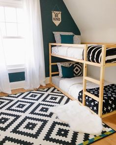 a bedroom with two bunk beds and black and white rugs on the floor in front of a window