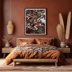 a bed with an orange comforter and pillows in front of a painting on the wall