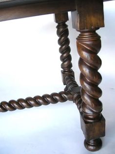 an old wooden table with spirally legs