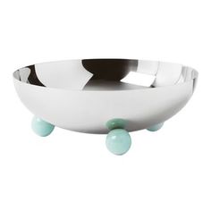 a white and black bowl with green balls in the bottom, on a white background