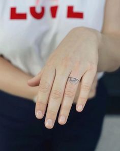 a woman's hand with a small tattoo on her left wrist and the word love written across it