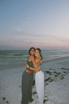 two women hugging each other on the beach