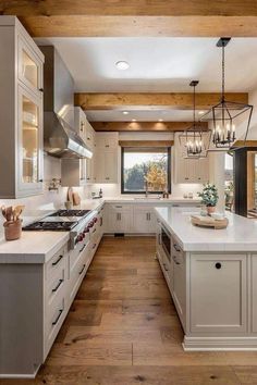 a large kitchen with white cabinets and wood flooring is seen in this image from the inside