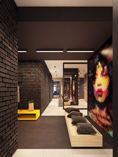 a room with black brick walls and yellow benches on the floor next to each other