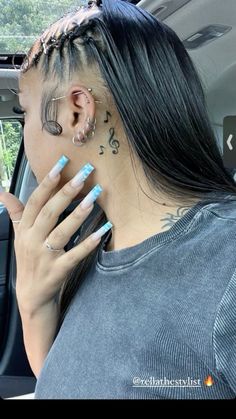 a woman sitting in the back seat of a car with her hand on her ear