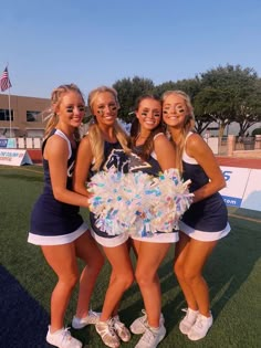 the cheerleaders are posing with their pom - poms on the field