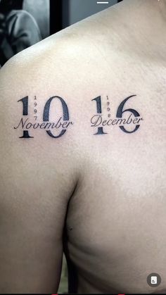 the back of a man's shoulder with numbers tattooed on it