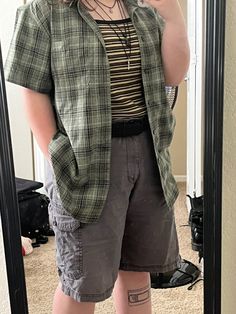 a selfie showing a person’s shoulders to mid-shin in a mirror. person is wearing a brown/yellow/black/white striped tank top, a green plaid short-sleeve button-up, and gray shorts. Also wearing a black belt and three black necklaces. a shin tattoo of a VHS tape is also shown. Plus Size Nonbinary Outfits, Fursona Outfit Ideas, Adrogonus Outfits Midsize, Grunge Outfit Midsize, Aesthetic Enby Outfits, Plus Size Summer Outfits Tomboy, Plus Masc Fashion, Gender Neutral Outfits Plus Size, Jorts Outfit Idea Midsize