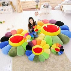 a woman sitting on top of a pile of stuffed animals in the middle of a room