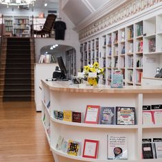 the inside of a book store with books on shelves and stairs leading up to the second floor