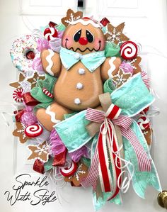 a christmas wreath with a teddy bear and candy canes on the front door hanger