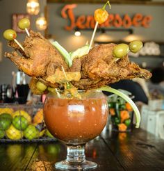 a glass filled with food sitting on top of a wooden table