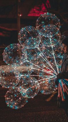 a person holding up bubbles in the dark