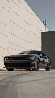 a black sports car parked in front of a building next to a skateboard ramp