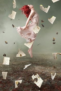 a woman flying through the air surrounded by papers