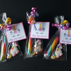 three unicorn shaped cookies in cellophane bags with tags attached to the top one