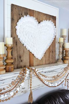 a white heart is hanging on the mantle