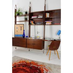 a living room with a rug and shelves on the wall