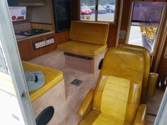 the inside of an rv with two chairs and a table in it, as well as other furniture