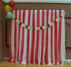 a red and white striped curtain with balloons