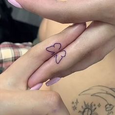 two hands holding each other with tattoos on their fingers and one is holding the other