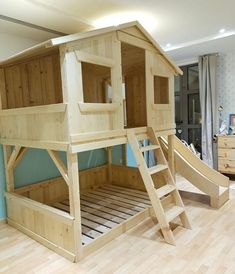 a wooden bunk bed with a slide in the middle