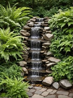 a small waterfall surrounded by plants and rocks