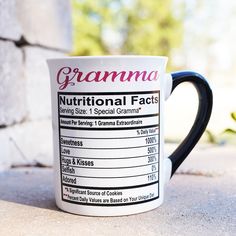 a black and white coffee mug with nutrition labels on it's side sitting on the ground