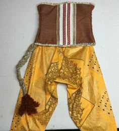 a yellow and brown outfit is hanging on the wall