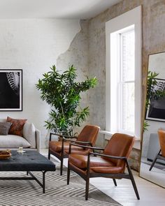 a living room filled with furniture and a painting on the wall