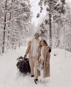 a man and woman walking through the snow