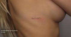 a woman's breast with the word love tattooed on her left side ribcage