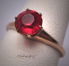 a close up of a ring with a red stone on it's center piece