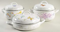 three white dishes with butterfly designs on them and one has a lid for the pot