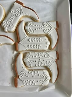 decorated cookies in the shape of horses on a white platter, with icing