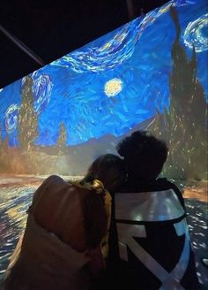 two people are looking at the starry night painting in an art museum, while another person is taking a photo