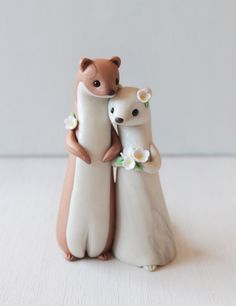 two small figurines are standing next to each other, one holding the other