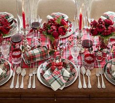 the table is set for christmas dinner with red and green plaid napkins on it